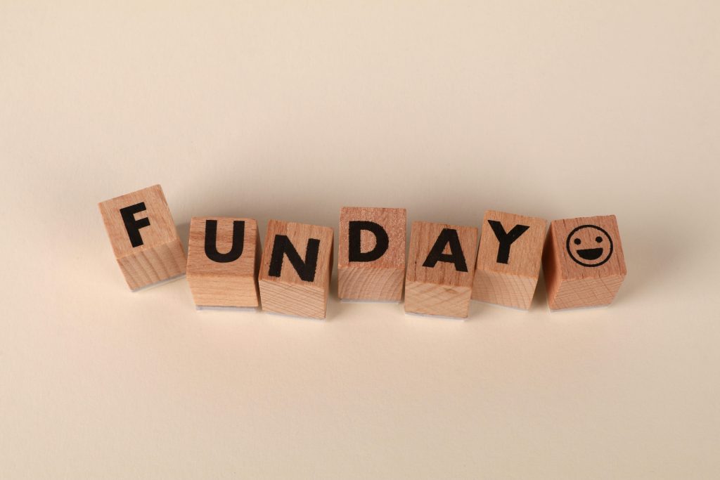 Wooden blocks spelling 'Funday' with a smiley face in a playful arrangement on a soft background.